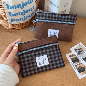 Detail of vintage suede and plaid card holder with cute puppy label and blue zipper