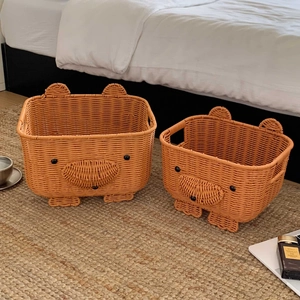Detail of woven bear-shaped storage baskets in caramel finish with handles and cute ears