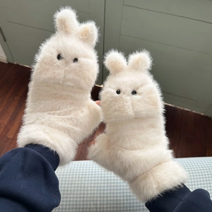 Close-up of cute cream plush flip gloves with rabbit ear design and soft faux fur texture