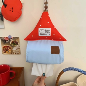 Detail of wall-mounted house-shaped tissue holder with red polka dots and blue fabric