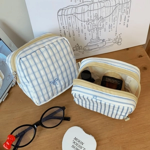 Detail of blue striped fabric pouch showing interior capacity for skincare products