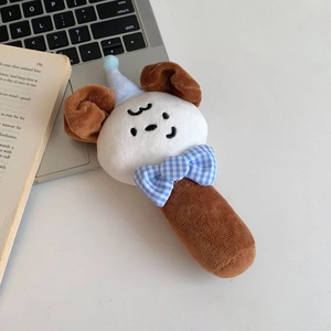 Close-up of soft plush puppy hand rattle with blue hat and bow for baby sensory play