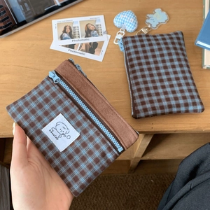 Close-up of retro plaid fabric coin purse with soft suede trim and a cute bear patch
