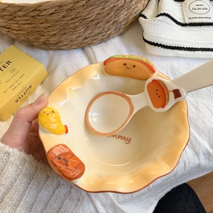 Detail of a creamy yellow ceramic bowl with 3D food charms and Yummy text decoration