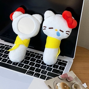 Cute plush cat handheld mirror and matching doll set on a desk with a laptop