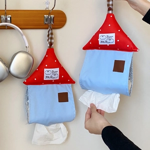 Detail of wall-mounted house-shaped fabric tissue holder in blue and red polka dot design