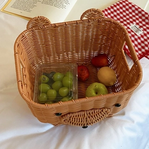 Detail of bear-shaped woven storage basket filled with fresh apples and lemons