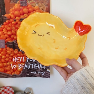 Close-up of fried shrimp shaped ceramic dessert plate with cute facial expression