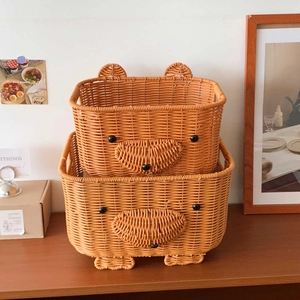 Set of two woven bear-shaped storage baskets in vibrant orange rattan-style material