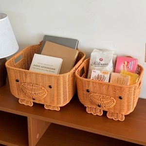 Detailed view of woven chicken storage baskets with cute eyes and orange beak on wood surface