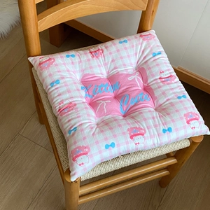 Detail of pink checkerboard chair cushion with plush texture and cute kitten embroidery