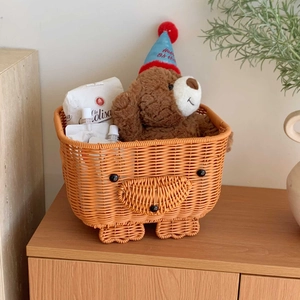 Detailed close-up of cute bear-shaped orange woven basket on a minimalist wooden surface