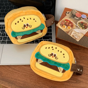 Close-up of yellow burger-shaped plush camera bags with cartoon embroidery and handles
