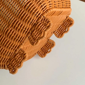 Close-up of caramel woven storage basket featuring clover-shaped stable support feet