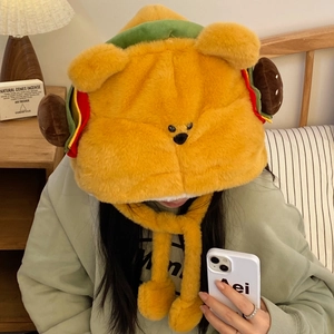 Détail du chapeau ours burger en peluche douce avec pompons et texture moelleuse