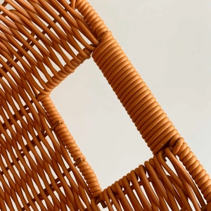 Macro detail of the woven texture and rectangular handle on a brown storage basket
