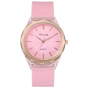 Detail of pink silicone strap and rose gold textured dial on a stylish quartz watch