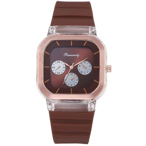Détails du bracelet en silicone marron et lunette or rose sur une montre à quartz carrée