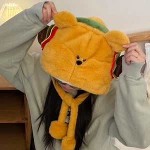 Détail du bonnet ours burger en peluche avec cache-oreilles et pompons pour l'hiver