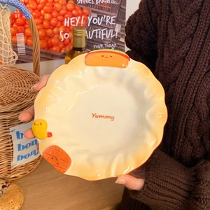Detail of a ceramic dessert plate with 3D food charms and embossed wavy edges