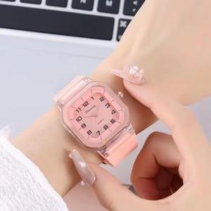 Gros plan d'une montre à quartz carrée rose avec bracelet en silicone au poignet