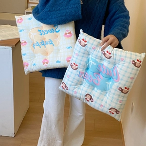 Detail of square plaid cushions with cute puppy and bear prints in a soft plush fabric