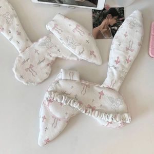 Detail of plush bunny ear sleep masks with angel prints and pink lace edges