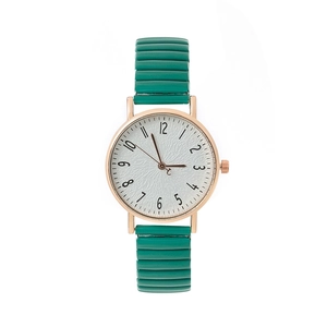 Detail of rose gold watch with green elastic strap and white dial with Arabic numerals