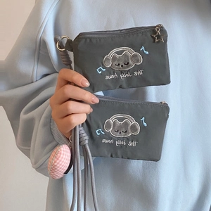 Detail of gray cat coin purse with star zipper, woven lanyard and plush charm