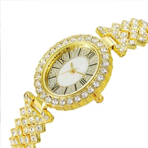 Montre de luxe dorée pour femme avec cadran ovale serti de cristaux et chiffres romains