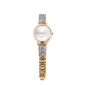 Macro dell'orologio al quarzo dorato con cinturino a catena decorato con cristalli su sfondo bianco