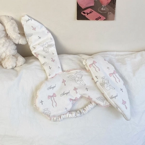 Detail of cute rabbit ear sleep mask with pink bow and angel print on soft fabric