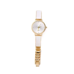 Dettaglio di elegante orologio al quarzo dorato con maglie in smalto bianco e quadrante