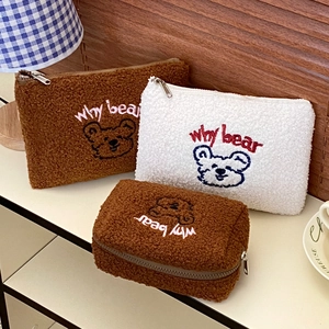 Detailed view of plush teddy fleece makeup bags featuring bear embroidery and zipper closure