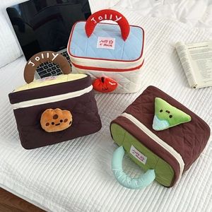 Detailed view of quilted makeup bags with cute plush charms and embroidered handles
