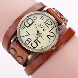 Close-up of vintage quartz watch with brown leather strap and bronze rivets detail