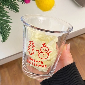 Detail of Christmas snowman glass cup with Merry Christmas print and festive decorations