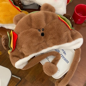 Détail du bonnet ours en peluche avec ornements burger 3D et texture douce en fausse fourrure