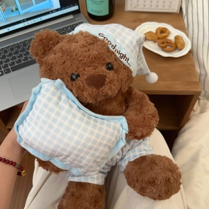 Plush teddy bear toy in blue checkered pajamas holding a pillow for sleeping