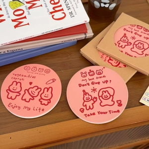 Cute pink ceramic coasters with cartoon rabbit and inspirational quotes on a wooden table