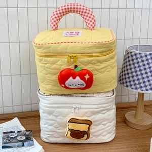 Dettaglio di trousse trapuntate con motivi a cuore e simpatici ciondoli di peluche