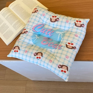Detail of checkered chair cushion featuring cute girl print and quilted fabric texture