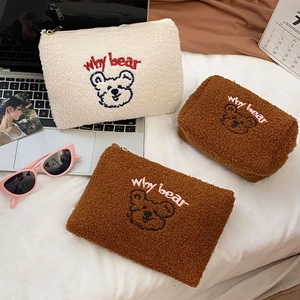 Detail of embroidered teddy bear cosmetic bag in sherpa fleece with a metal zipper