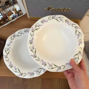 Detailed view of the wavy scalloped edges and purple lavender patterns on ceramic plate