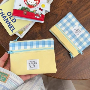 Detail of canvas zippered pouch showing dual-color checkered pattern and dog label