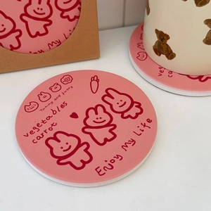 Detailed view of pink ceramic coasters with cute rabbit and carrot line art pattern