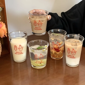 Close-up of glass cups with red Christmas snowman prints and festive tree patterns