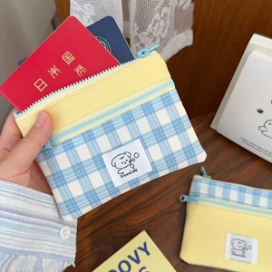 Detail of yellow and blue checkered pouch holding cards on a wooden tabletop