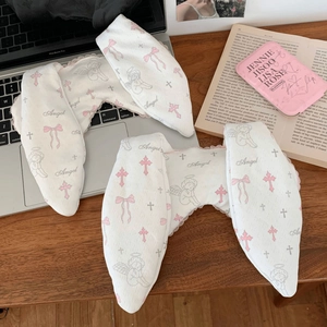 Detail of white waffle fabric eye mask with pink lace and cute angel prints on wood desk