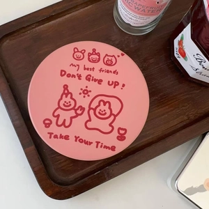 Detail of pink ceramic coaster with red cartoon animal illustrations and inspiring quotes
